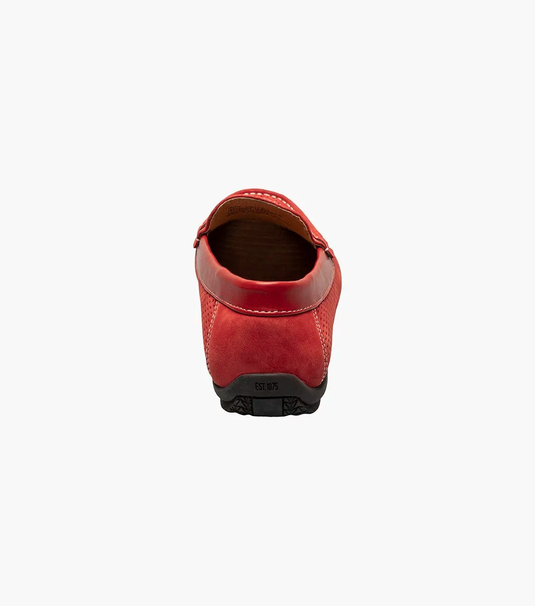 Introducing the Stacy Adams - CORBY Moc Toe Saddle Slip On in Red (25513-600). This shoe features a red leather loafer design with a perforated upper, complemented by black and red stripe detailing on top. It also boasts a durable rubber outsole, making it the ideal casual warm-weather shoe with its stylish appearance and comfortable fit from STACY ADAMS.