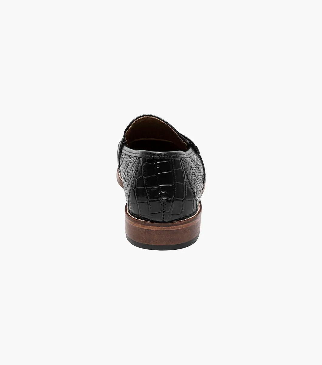 From the Stacy Adams PACETTI collection, this black leather Moc Toe Tassel Slip On loafer features a textured finish, memory foam insole, and brown sole against a white background.