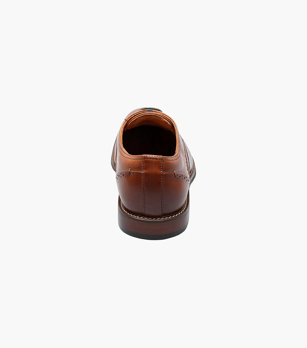 The Stacy Adams - MACARTHUR Wingtip Oxford in Cognac (25489-221) showcases a polished leather design with detailed brogue accents against a white background.