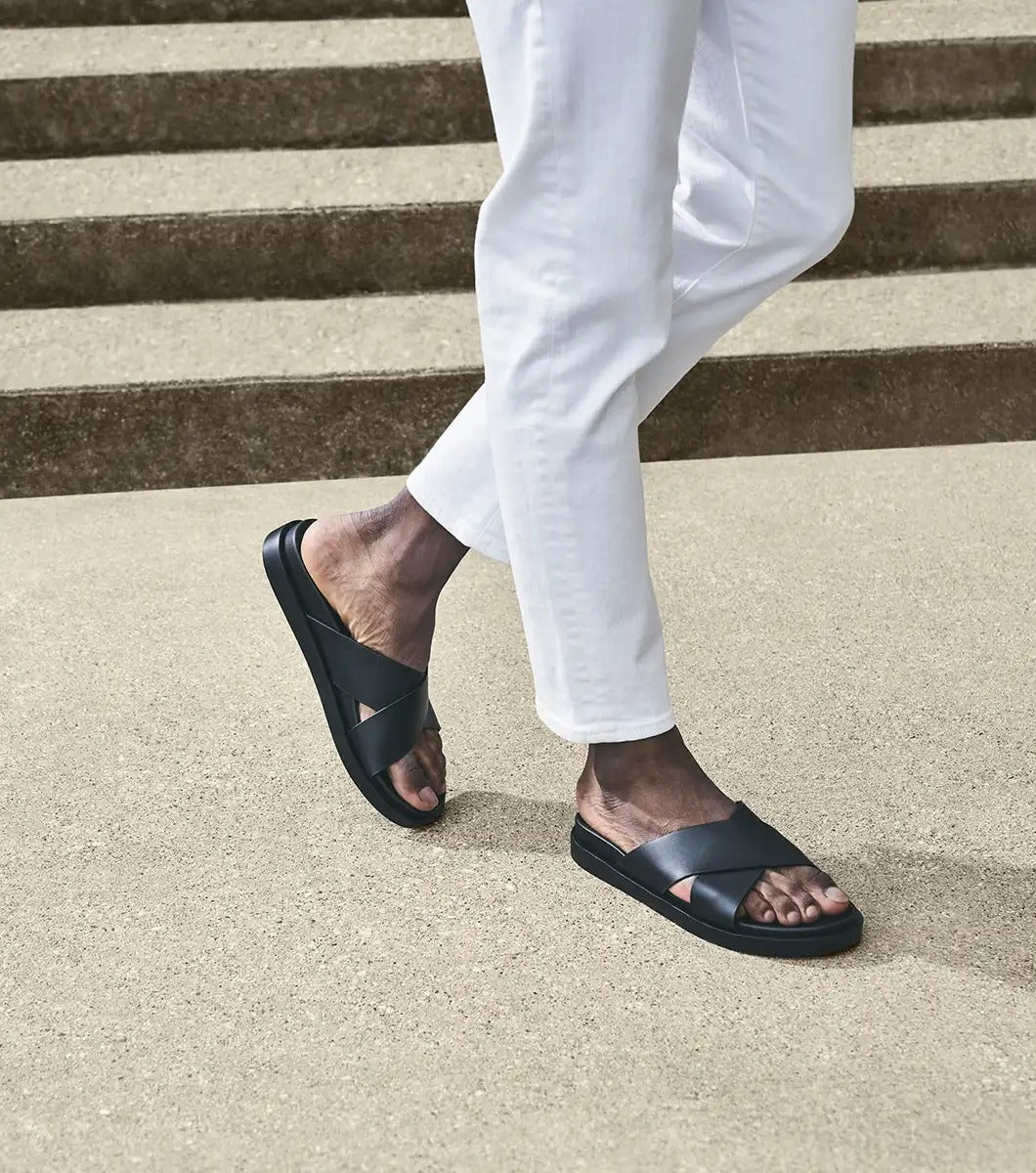 The STACY ADAMS - MONTEL Cross Strap Slide Sandal in Black (Product Number: 25469-001) showcases a sleek design featuring crisscross straps and a comfortable flat sole, complete with a cushioned insole for all-day support.