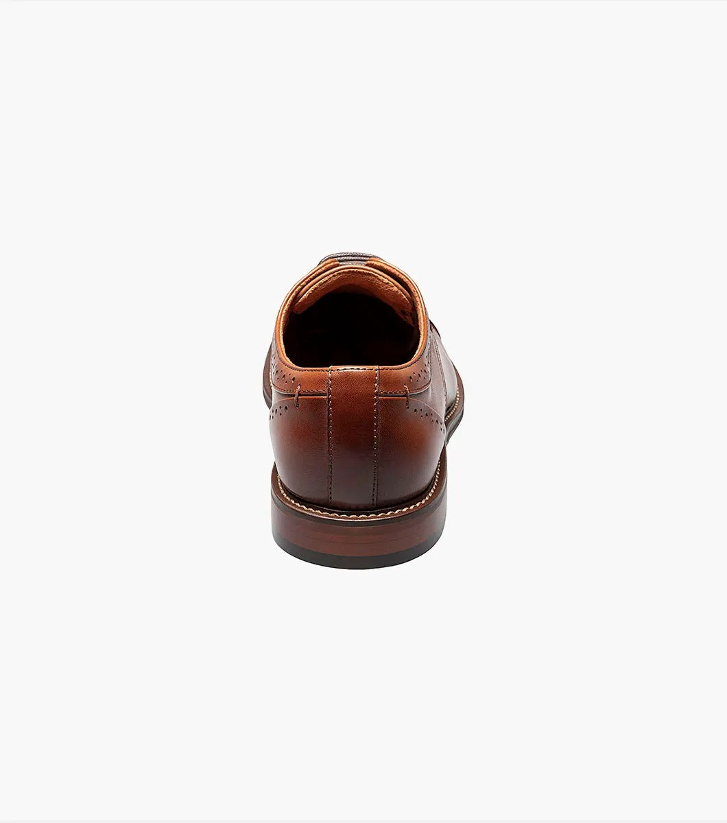 The Stacy Adams MADDOX Cap Toe Oxford in Cognac boasts a burnished leather finish, enhanced with a stylish cap toe and decorative perforations on the sides.