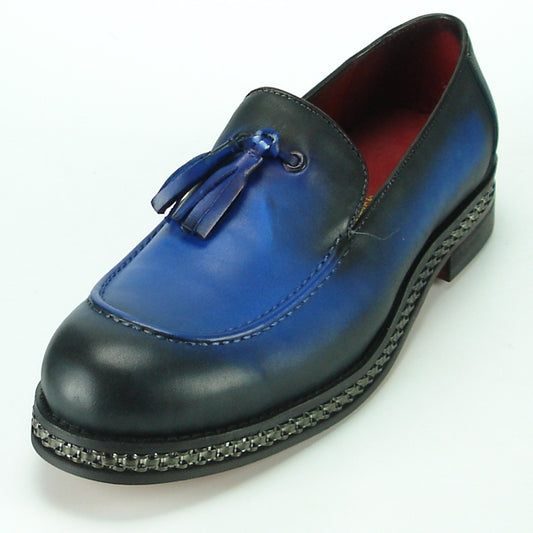 The FI-7123 Blue Fiesso by Aurelio Garcia, from the Fiesso brand, is a stylish loafer that boasts a striking black and blue gradient accompanied by tassels. It features a vibrant red interior and elegant chain detailing around the sole. Made with a premium leather upper and equipped with a cushioned insole, this loafer seamlessly merges style with comfort.