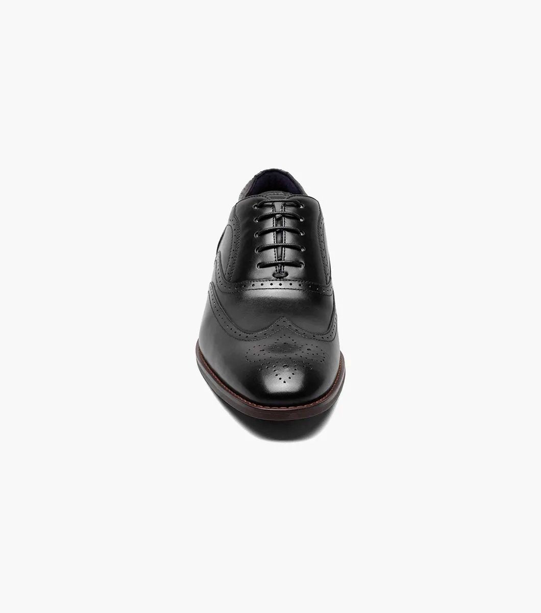 Presenting the Stacy Adams - KAINE Wingtip Oxford in Black, style number 25569-001, from STACY ADAMS. This shoe boasts a classic wingtip design with decorative perforations and laces, featuring a low heel and sleek profile. It is crafted for comfort with anatomical arch support.