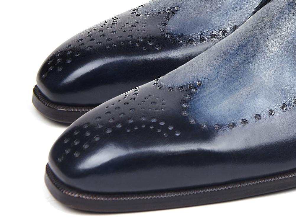 The Paul Parkman Wingtip Single Monkstraps Navy - 98F54-NVY are a pair of elegant navy leather dress shoes with brogue detailing and a monkstrap buckle, displayed on a white background. These handmade shoes from Paul Parkman are perfect for adding a touch of sophistication to any ensemble.