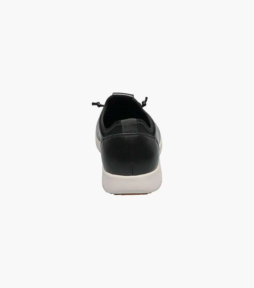 The Stacy Adams - HALDEN Lace Up Sneaker in black showcases a burnished leather upper and perforated side details, set against a plain white backdrop. It features a white rubber sole and cushioned footbed for optimal comfort.