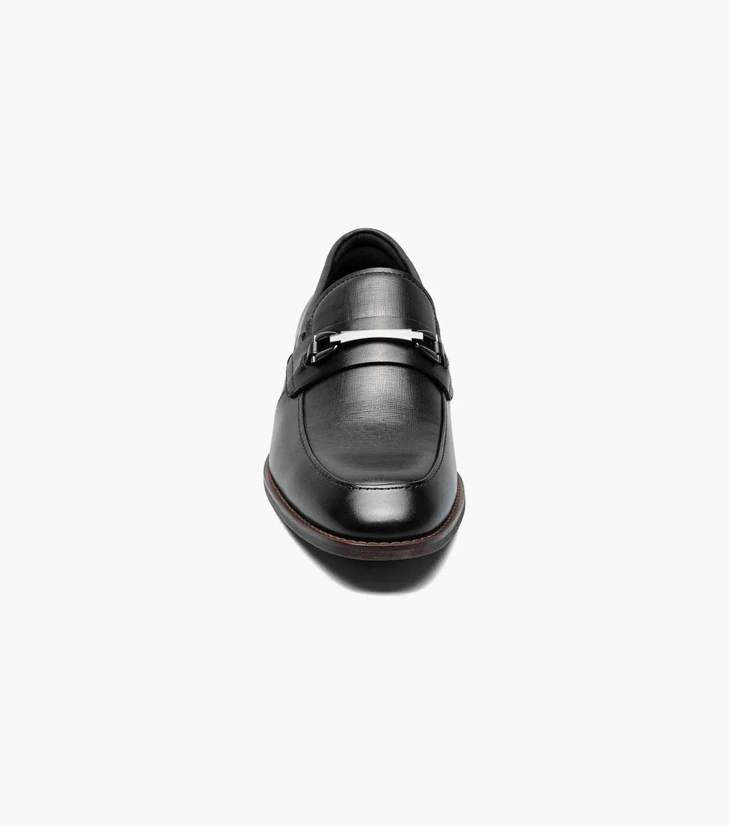 The Stacy Adams KAYLOR Moc Toe Bit Slip On in black (model 25572-001) is a sophisticated leather loafer from STACY ADAMS, highlighted by a sleek metal buckle, wooden heel, and premium leather upper. Perfectly set against a white background, it features the supportive RedZone footbed for exceptional comfort.