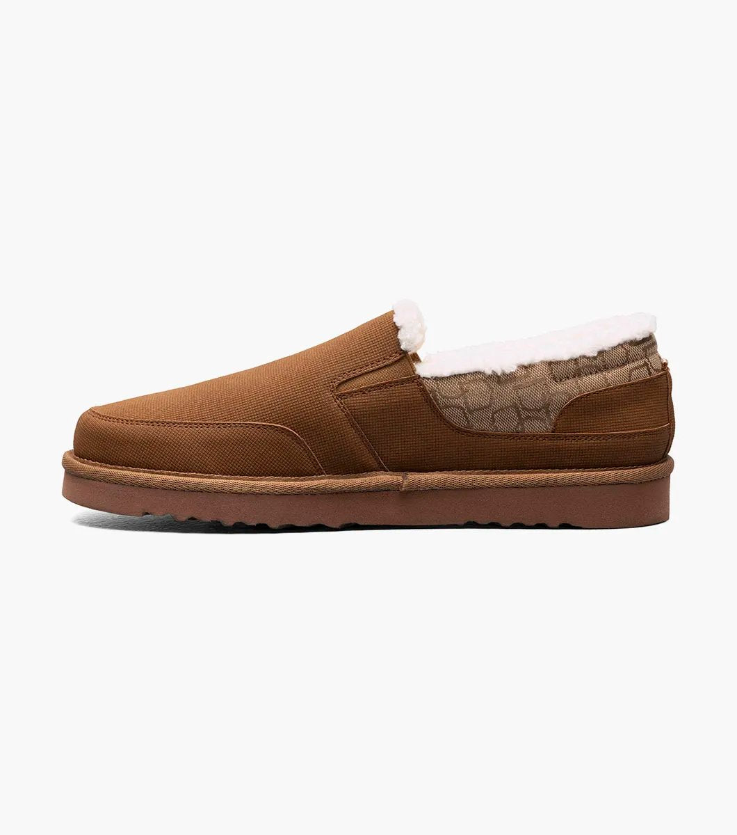 The Stacy Adams - COZE Moc Toe Slip On - Tan Multi - 25558-238, from STACY ADAMS, boasts a textured fabric exterior and soft faux shearling lining. It features a cushioned insole and a brown rubber sole.