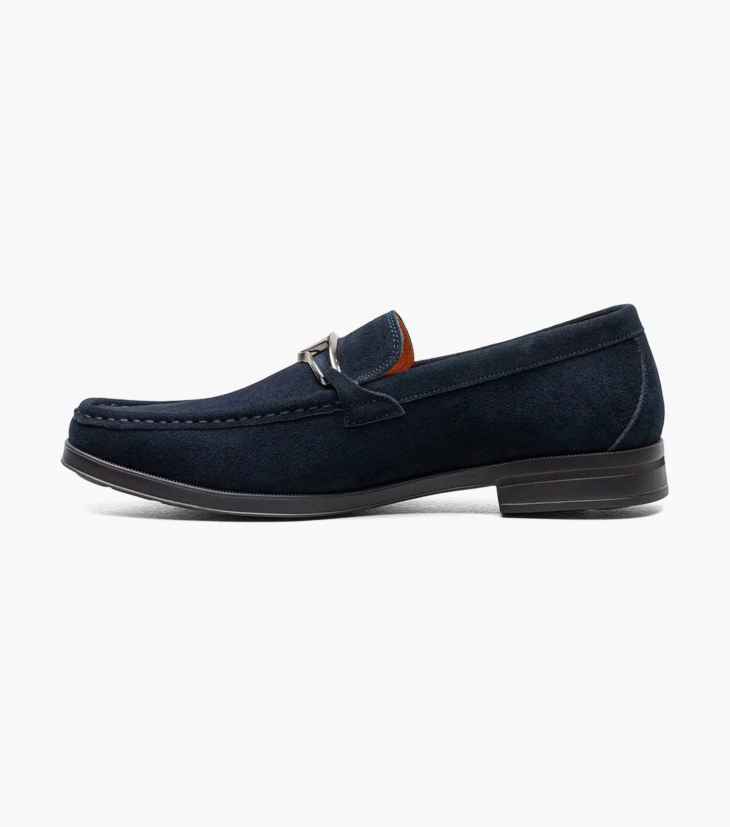 Stacy Adams introduces the PALLADIAN Moc Toe Slip On in Navy Suede (25549-415), showcasing a soft suede upper, metallic buckle detail, and black sole with a fully cushioned insole for exceptional comfort.