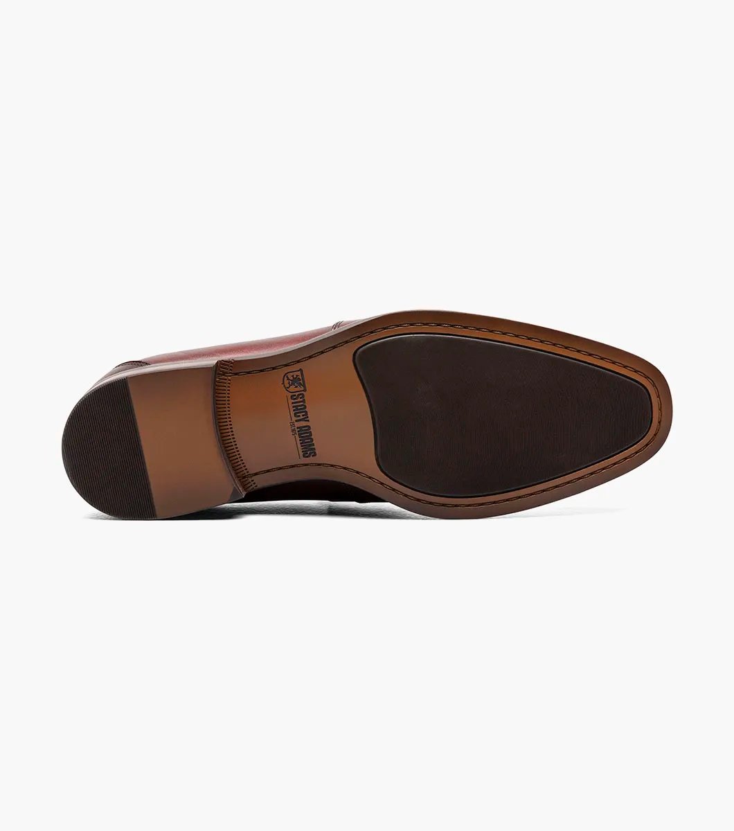 The Stacy Adams KAYLOR Moc Toe Bit Slip On in Burgundy, product number 25572-601, features a metal buckle detail, leather upper, low heel, and dark sole set against a plain white background.