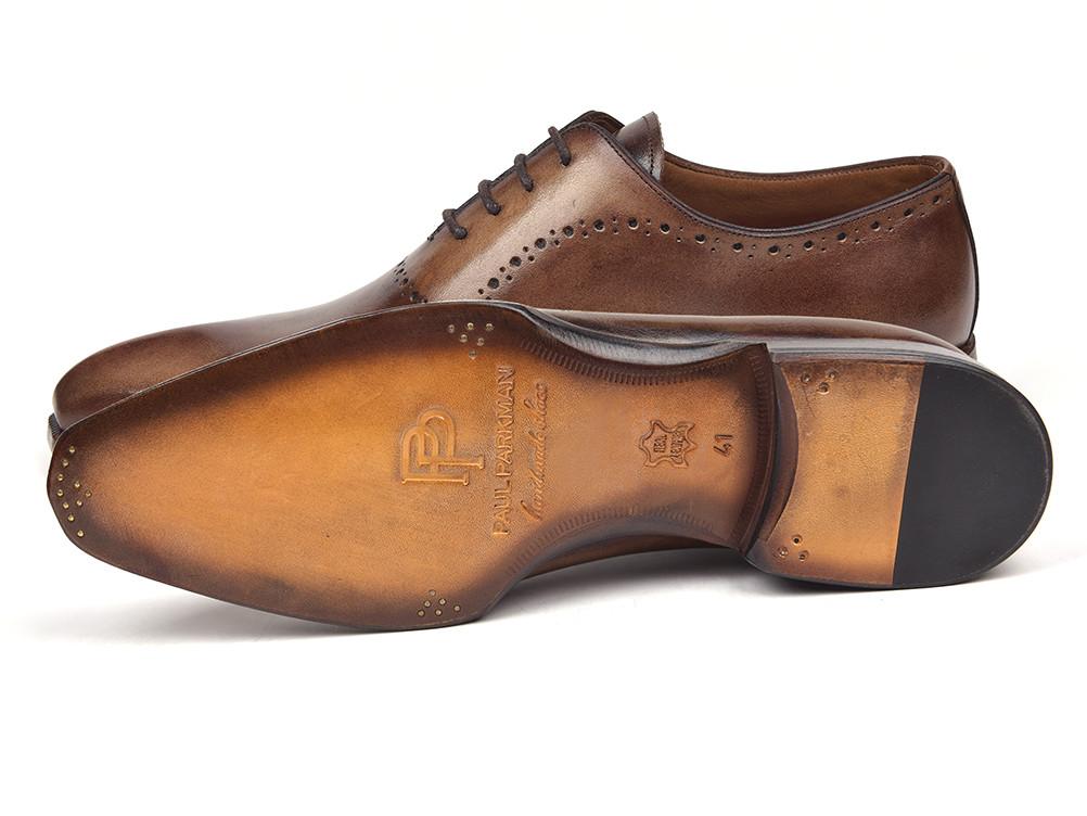 A pair of Paul Parkman Antique Brown Oxfords, featuring decorative perforations and black laces, are crafted from antique burnished leather for a timeless finish.