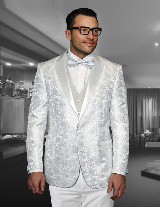 A man dressed in the STATEMENT CLOTHING | BELLAGIO-4-WHITE, a slim fit, patterned white suit from Statement Clothing, featuring flat front pants and a bow tie, stands in an elegant room, wearing glasses.