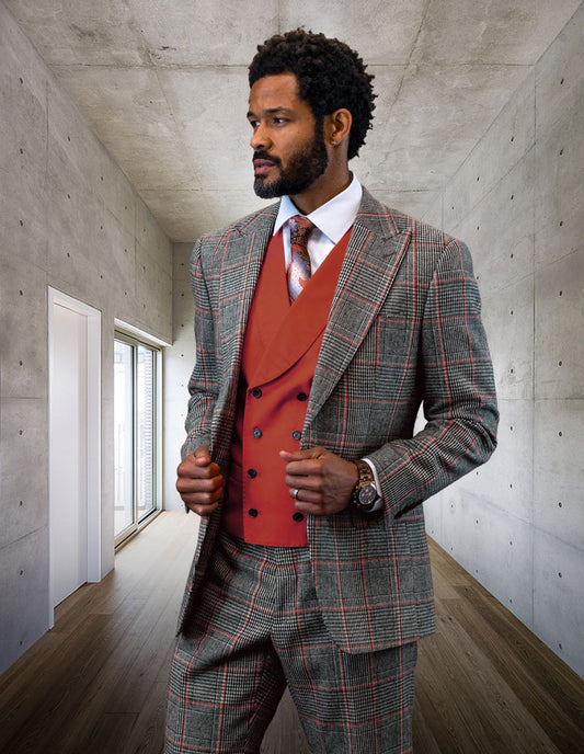 A man in a STATEMENT CLOTHING | BENSON-COPPER suit from Statement Clothing, featuring a tailored fit plaid design made of fine Italian wool with a red vest, stands in a modern concrete hallway.