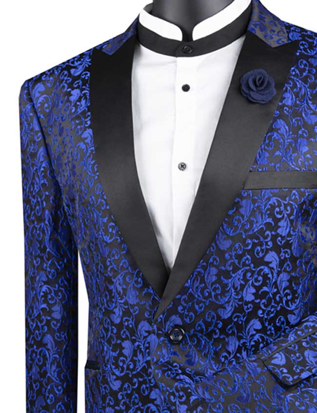 The Vinci Regular Fit Floral Pattern Jacket Peak Lapel (Blue) BF-2 by Vinci Suits showcases a blue floral design with contrasting black lapels and comes with a coordinating pocket square. Made from a comfortable poly/rayon blend, it pairs effortlessly over a white shirt featuring a crisp black collar for an elegant and stylish appearance.