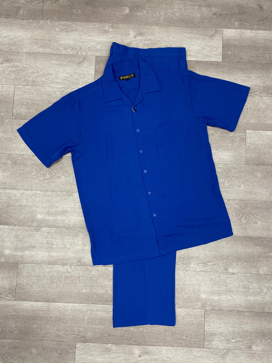 The trendy ensemble includes the Inserch 2pc 9356 Imperial Blue, consisting of a short-sleeve button-up microfiber shirt and matching pants in a striking blue shade, all elegantly displayed on a wooden floor. Perfect for any relaxed occasion, this outfit by Inserch offers both style and comfort.