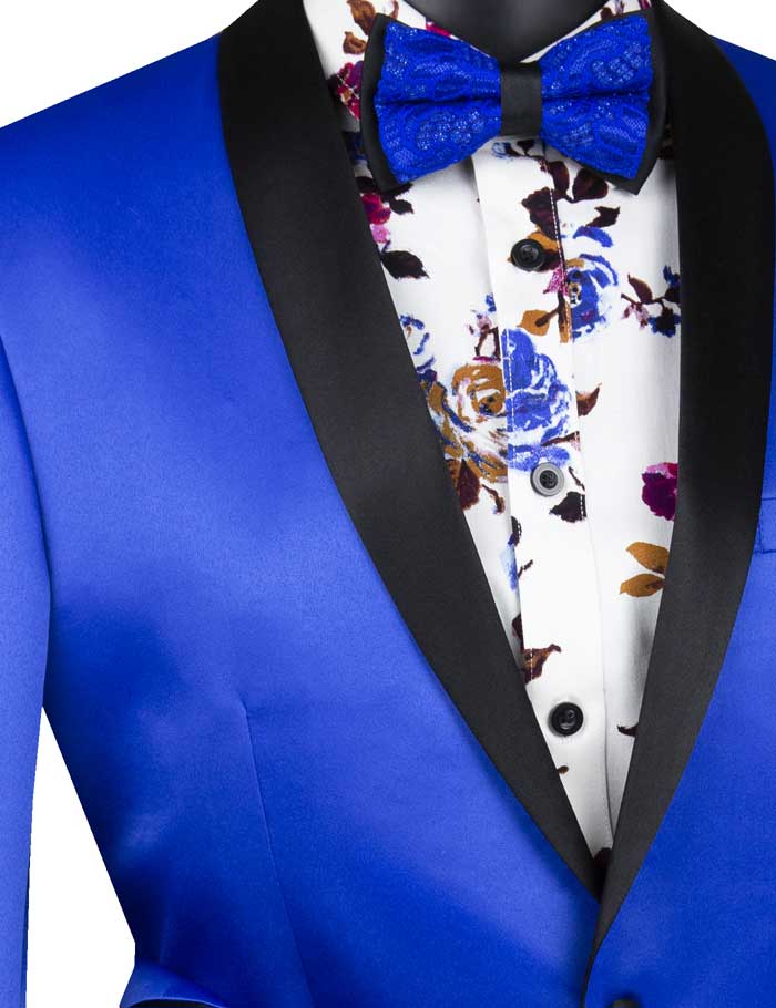 A striking ensemble is presented with the Vinci Slim Fit Sport Coat with Narrow Shawl Lapel in Royal Blue from Vinci Suits, featuring black lapels, paired with a floral shirt and a matching blue bow tie on a mannequin. This sport coat design ensures style while remaining wrinkle resistant for any occasion.