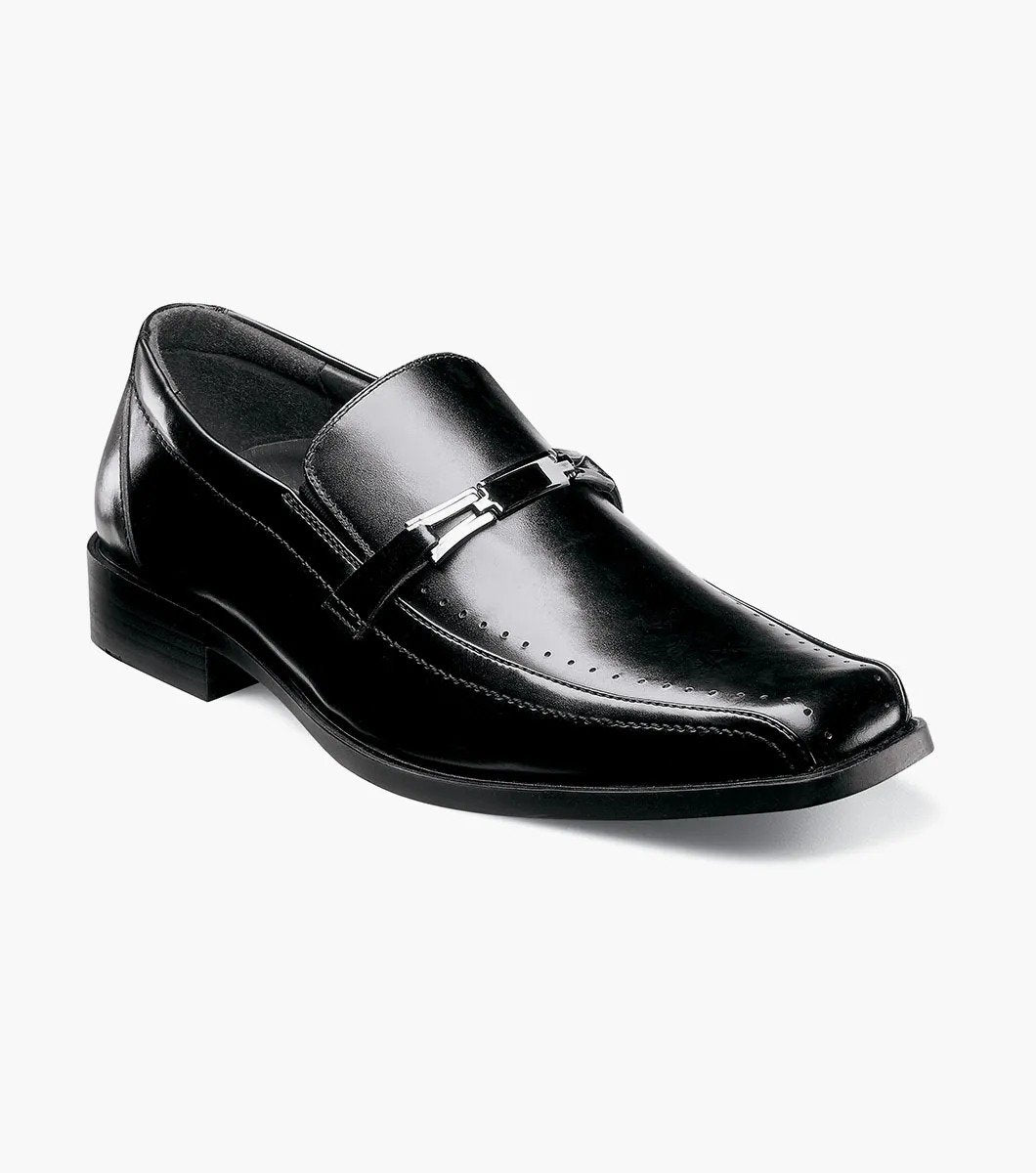 The Stacy Adams CADE Bike Toe Slip On in black, model 20126-001, is a stylish black leather loafer with a slip-on design. It features a gunmetal bit and a low heel, set against a plain white background.