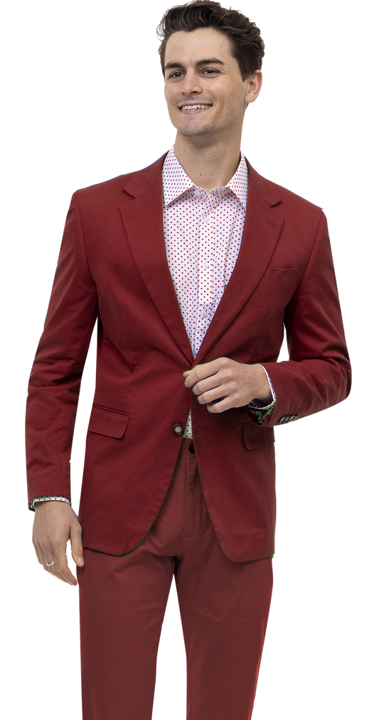 A man in a striking EJ Samuel Burgundy Solid Chino Blazer CHJ01, complemented by a white polka dot shirt and sharp ensemble, stands smiling.