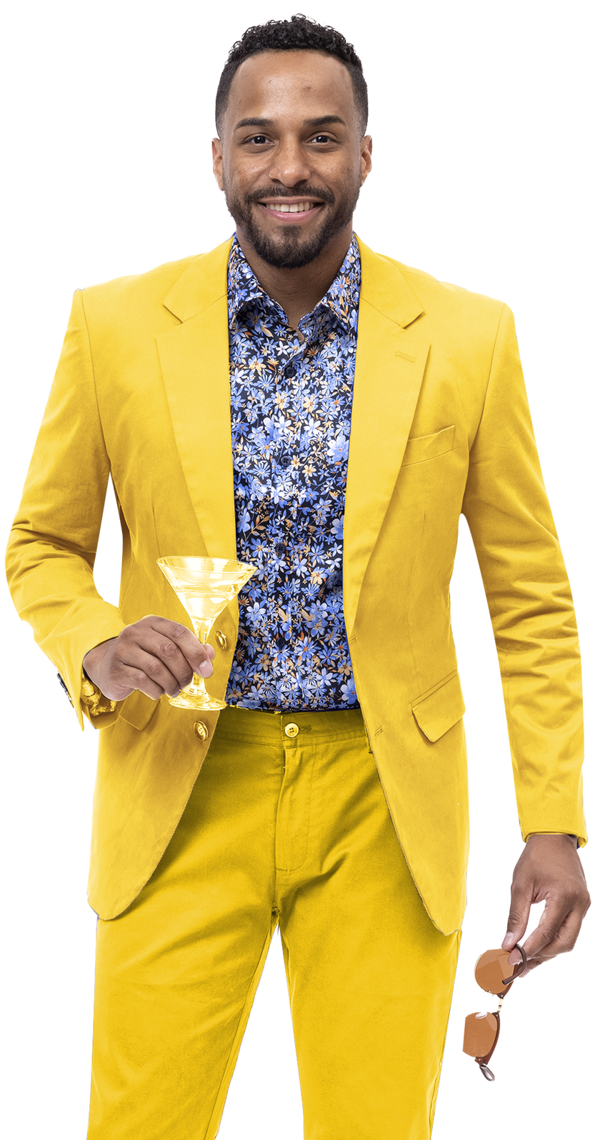 A person in an EJ Samuel Yellow Solid Chino Blazer CHJ01 and a floral shirt holds a martini glass and a pair of sunglasses, smiling at the camera.