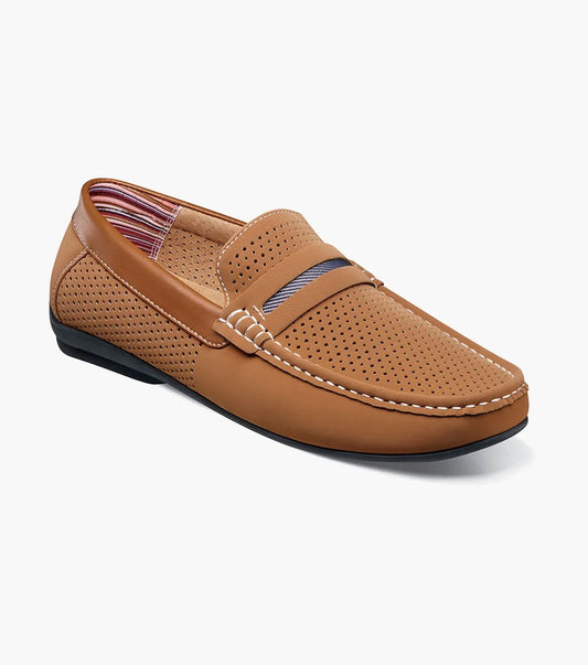 The Stacy Adams CORBY Moc Toe Saddle Slip On in Tan (25513-240) is a stylish casual shoe crafted from perforated tan leather, featuring intricate stitching details and a strap across the top, complemented by a striped interior lining and sole. It's ideal for laid-back days in the sun, offering both style and comfort.