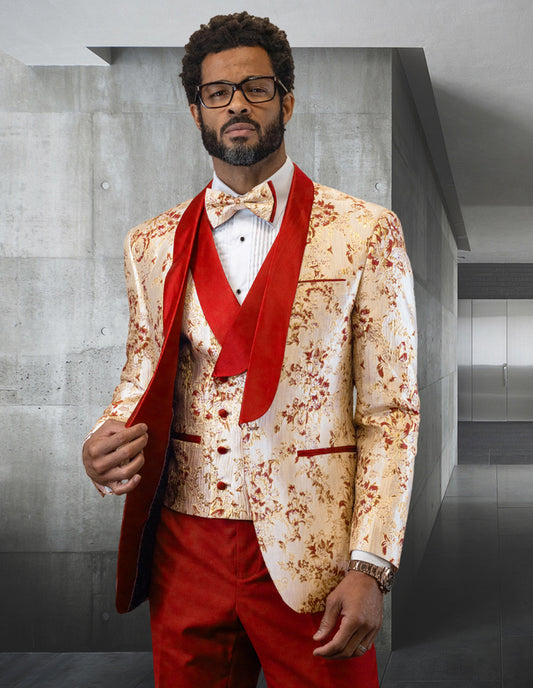 A person dressed in the DELANO-CORAL suit by Statement Clothing, featuring red accents and a coral bow tie, stands in a modern, minimalist room.