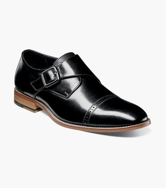 The Stacy Adams - DESMOND Cap Toe Monk Strap in Black, model number 25162-001, showcases a sophisticated black leather design with a cap toe and buckle strap, enhanced by a brown sole and a comfortable memory foam insole.