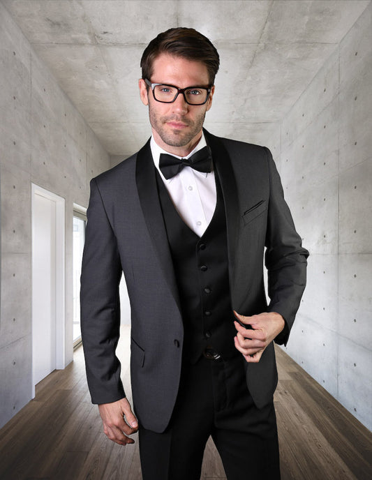 A man wearing the STATEMENT CLOTHING | ENCORE-CHARCOAL from Statement Clothing, featuring a tailored fit and flat front pants, stands in a modern concrete hallway with wooden flooring, looking directly at the camera.