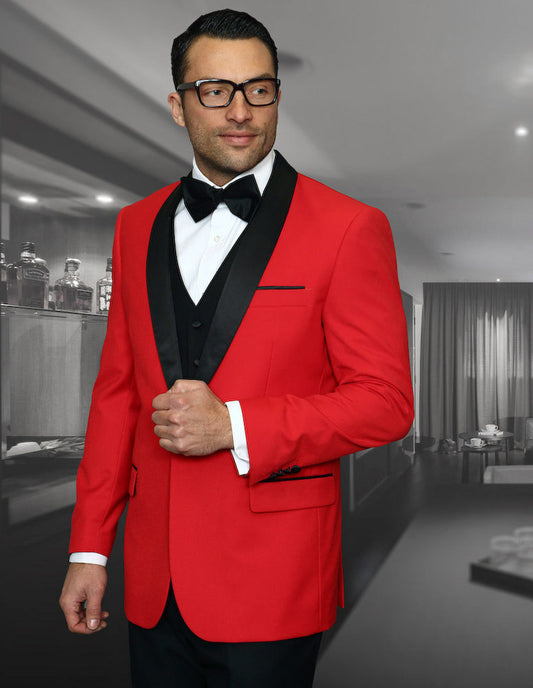 A man in the Encore-Red tuxedo by Statement Clothing, featuring a black lapel and bow tie, stands confidently in a stylish room.