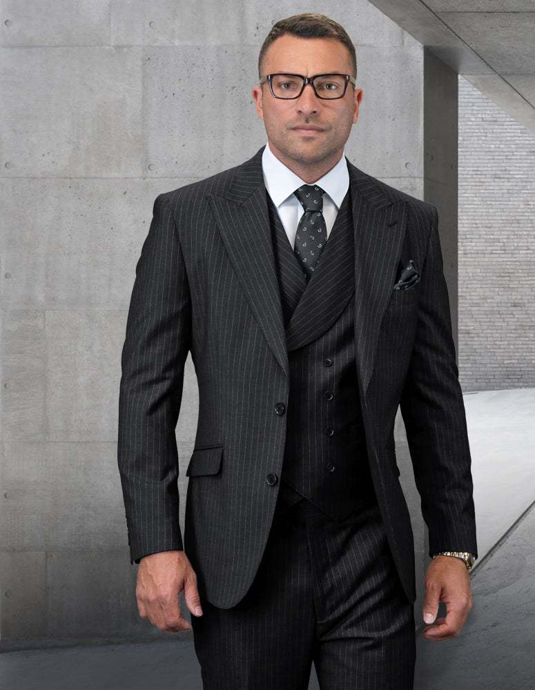 A man in the stunning STATEMENT CLOTHING | EXPLO-BLACK pinstripe suit from Statement Clothing, crafted from luxurious Italian wool, stands confidently in a modern concrete hallway, looking directly at the camera.