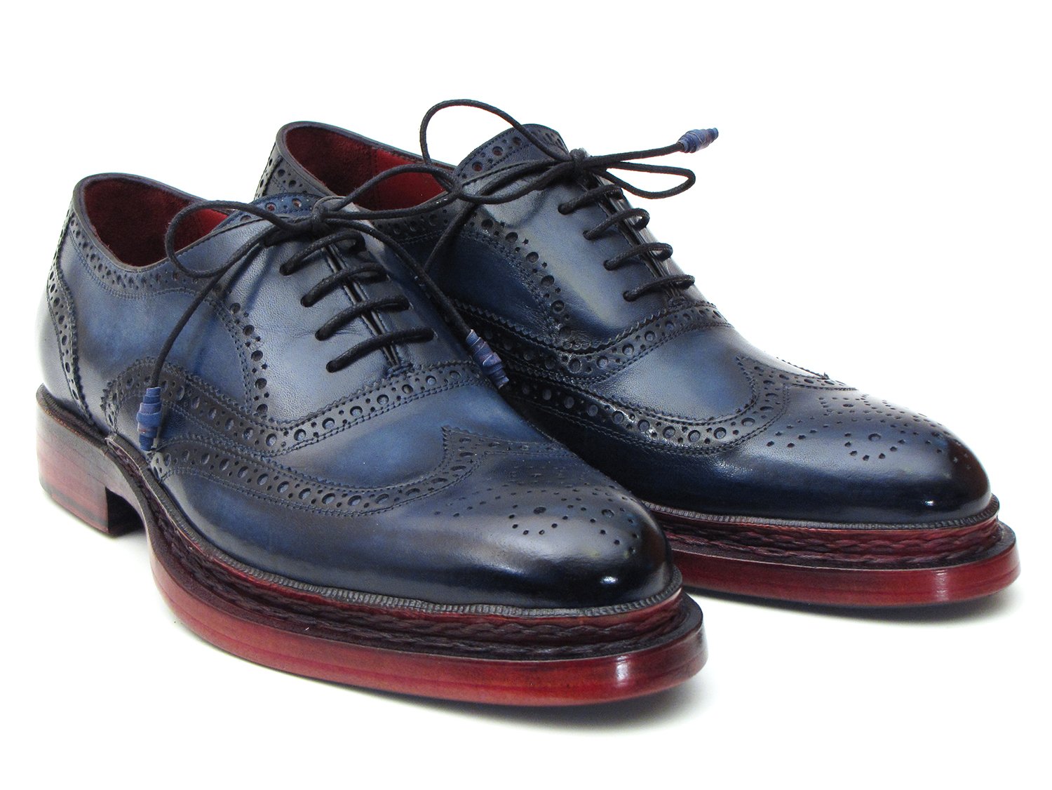 Introducing the Paul Parkman Triple Leather Sole Navy Wingtip Oxfords - 027TRPNVY. These navy wingtip oxfords by Paul Parkman showcase exquisite craftsmanship with intricate perforations and striking red-brown soles. Hand-painted to perfection, they feature a Goodyear welted construction for enduring elegance and durability.