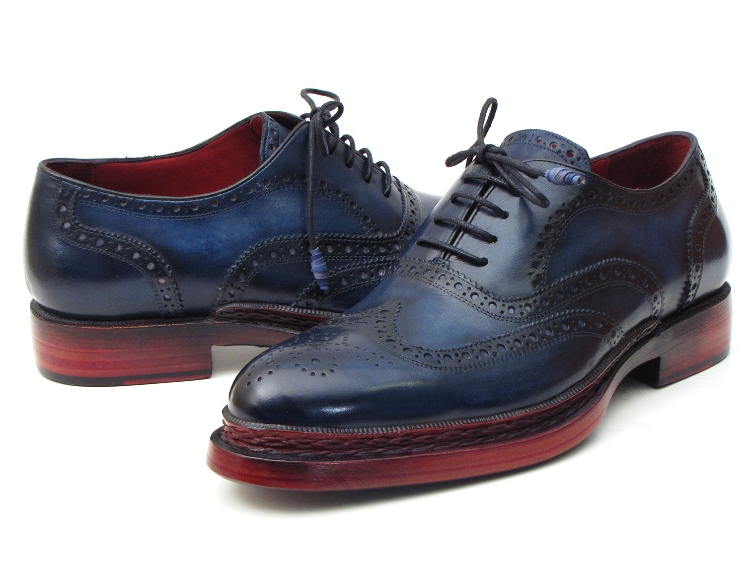 Introducing the Paul Parkman Triple Leather Sole Navy Wingtip Oxfords - 027TRPNVY. These navy wingtip oxfords by Paul Parkman showcase exquisite craftsmanship with intricate perforations and striking red-brown soles. Hand-painted to perfection, they feature a Goodyear welted construction for enduring elegance and durability.