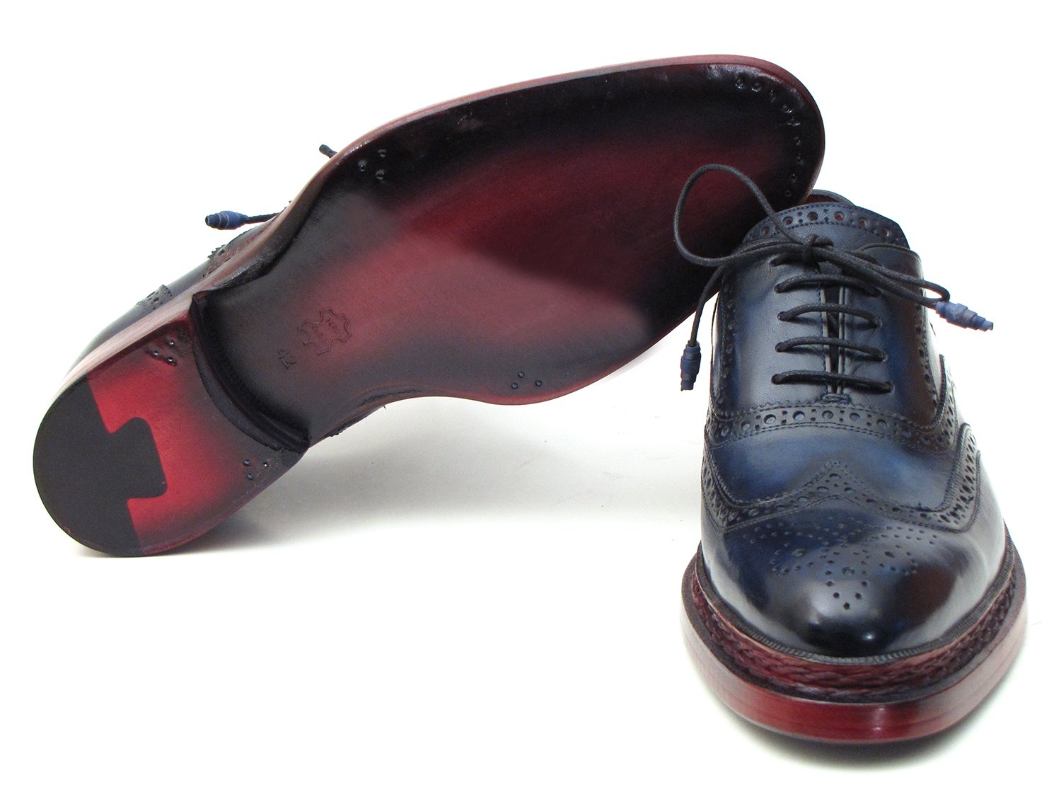 Introducing the Paul Parkman Triple Leather Sole Navy Wingtip Oxfords - 027TRPNVY. These navy wingtip oxfords by Paul Parkman showcase exquisite craftsmanship with intricate perforations and striking red-brown soles. Hand-painted to perfection, they feature a Goodyear welted construction for enduring elegance and durability.