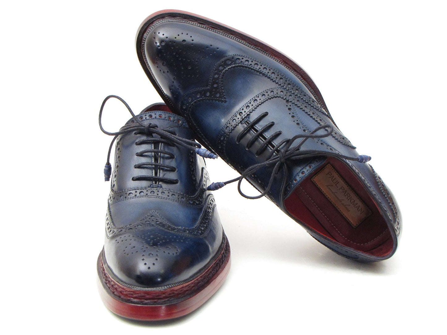 Introducing the Paul Parkman Triple Leather Sole Navy Wingtip Oxfords - 027TRPNVY. These navy wingtip oxfords by Paul Parkman showcase exquisite craftsmanship with intricate perforations and striking red-brown soles. Hand-painted to perfection, they feature a Goodyear welted construction for enduring elegance and durability.