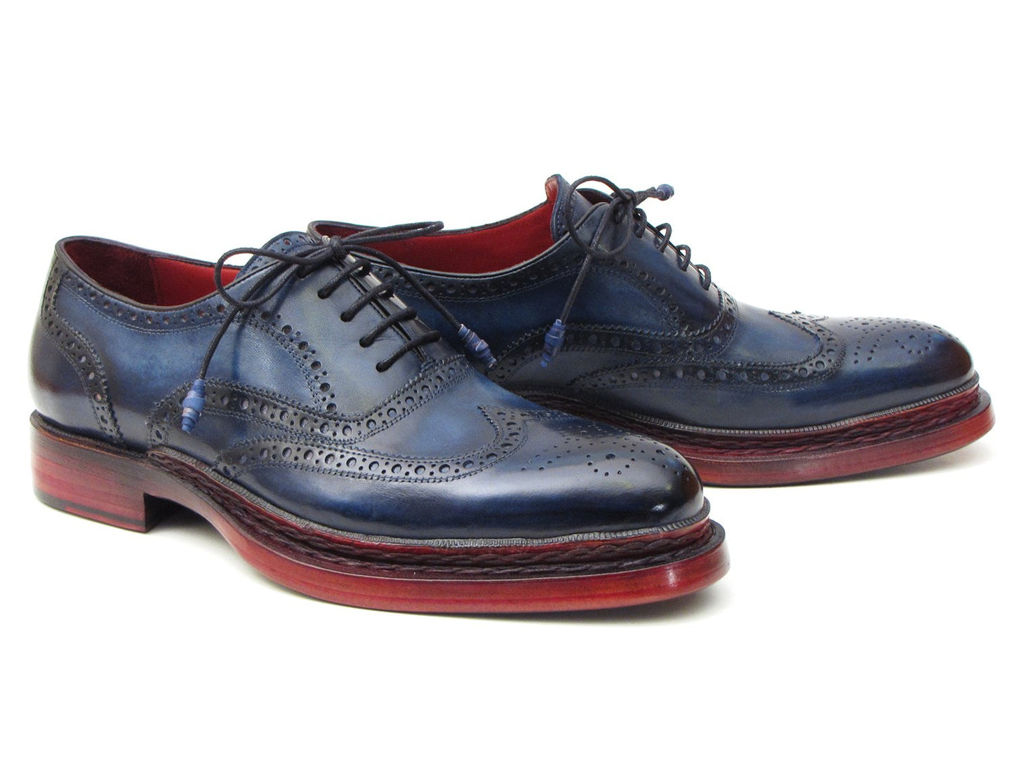 Introducing the Paul Parkman Triple Leather Sole Navy Wingtip Oxfords - 027TRPNVY. These navy wingtip oxfords by Paul Parkman showcase exquisite craftsmanship with intricate perforations and striking red-brown soles. Hand-painted to perfection, they feature a Goodyear welted construction for enduring elegance and durability.