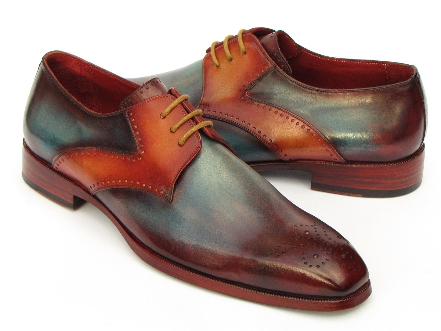 The Paul Parkman Multicolor Medallion Toe Derby Shoes (6584-MIX) are hand-painted dress shoes crafted in polished leather. They exhibit a captivating gradient of bordeaux, teal, and brown tones, featuring decorative perforations with a medallion toe design. These shoes are elegantly enhanced by brown laces.