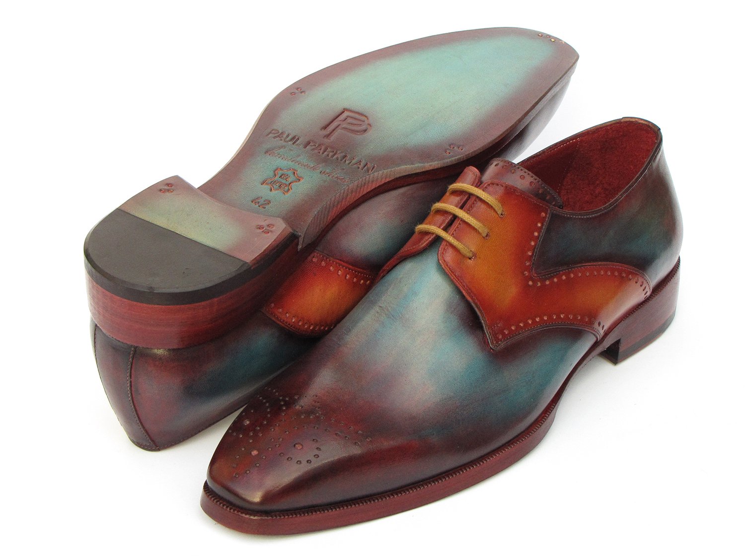 The Paul Parkman Multicolor Medallion Toe Derby Shoes (6584-MIX) are hand-painted dress shoes crafted in polished leather. They exhibit a captivating gradient of bordeaux, teal, and brown tones, featuring decorative perforations with a medallion toe design. These shoes are elegantly enhanced by brown laces.