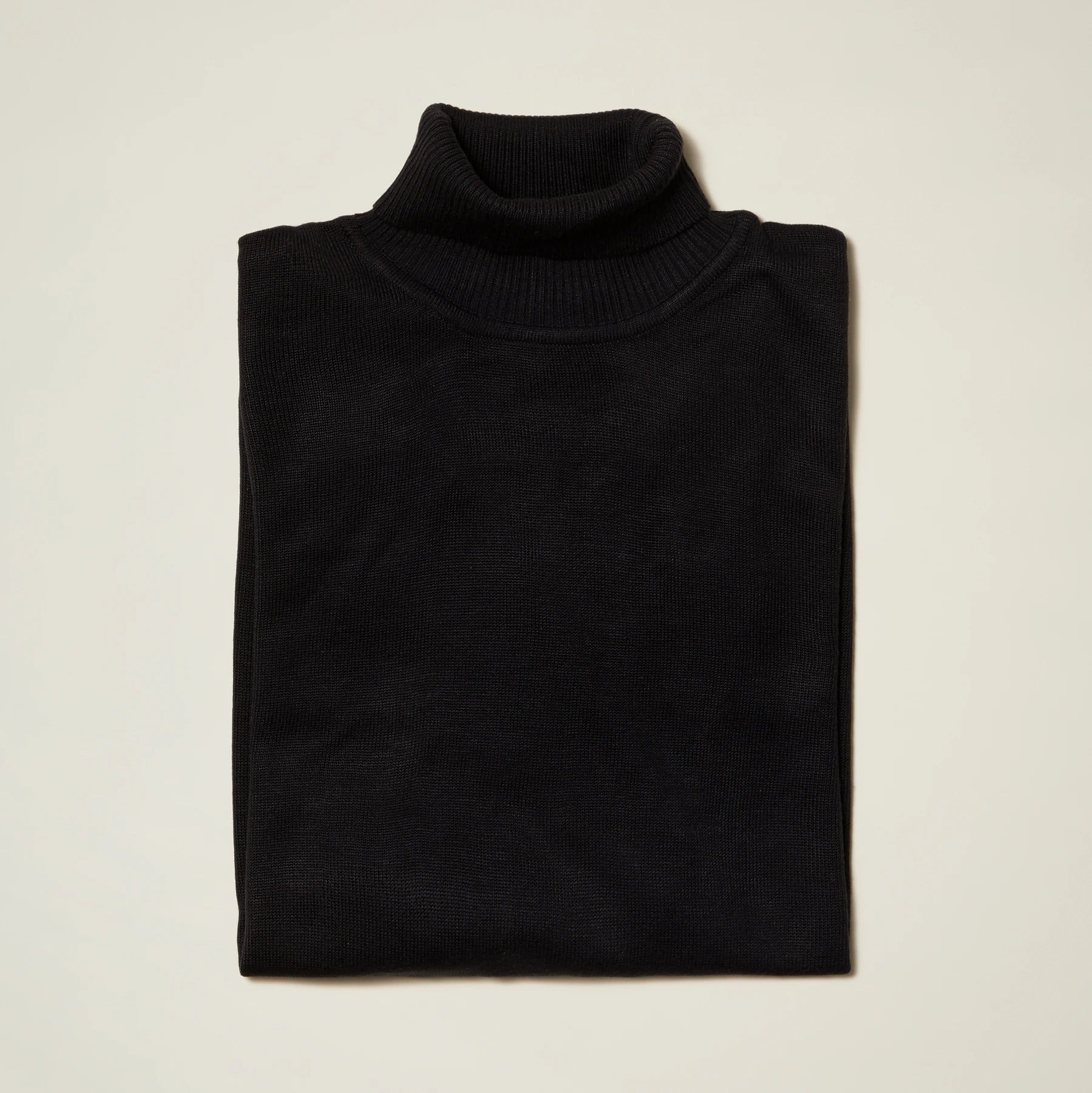 Inserch Cotton Blend Turtleneck Sweater Black 4708 by Inserch, elegantly folded against a light background, offering a polished look.