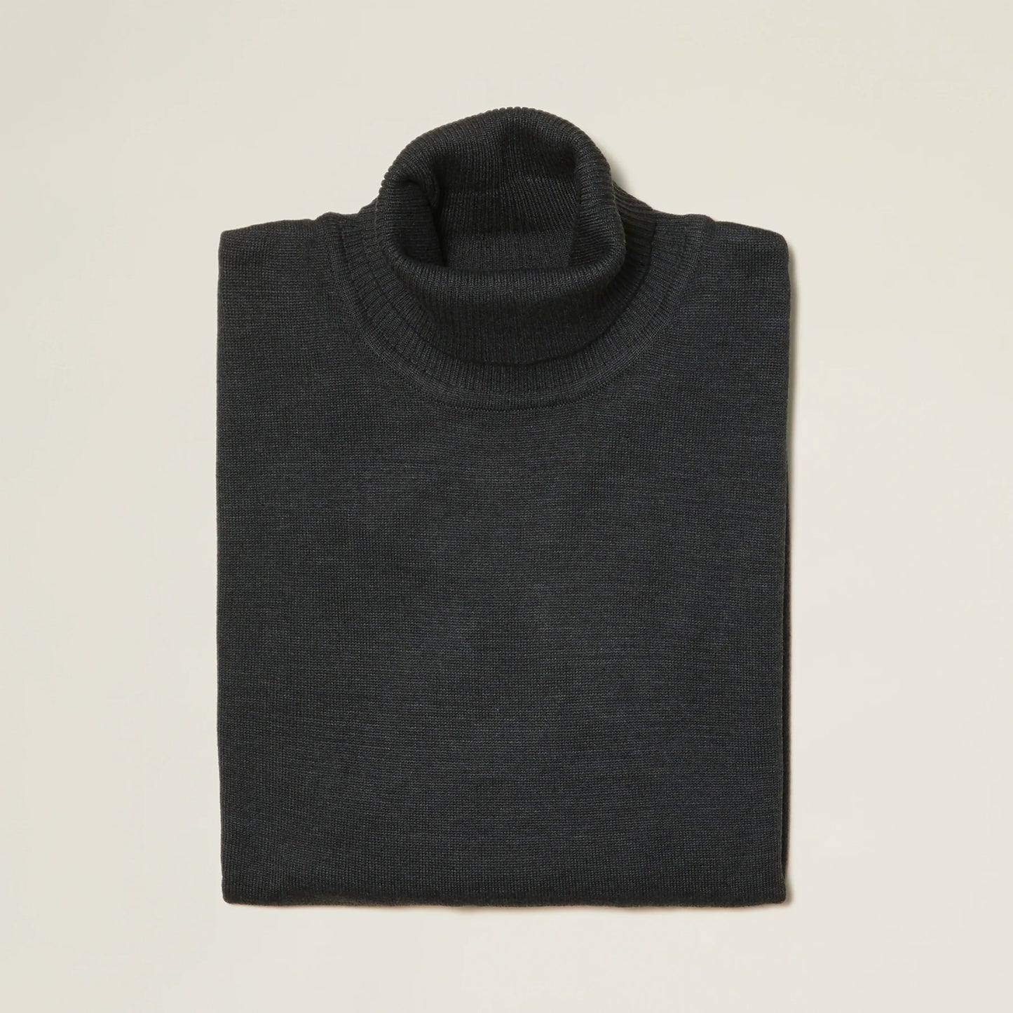 The Inserch Cotton Blend Turtleneck Sweater in Charcoal 4708, made from a soft cotton blend, is folded on a light background and viewed from above, making it perfect for fall fashion.