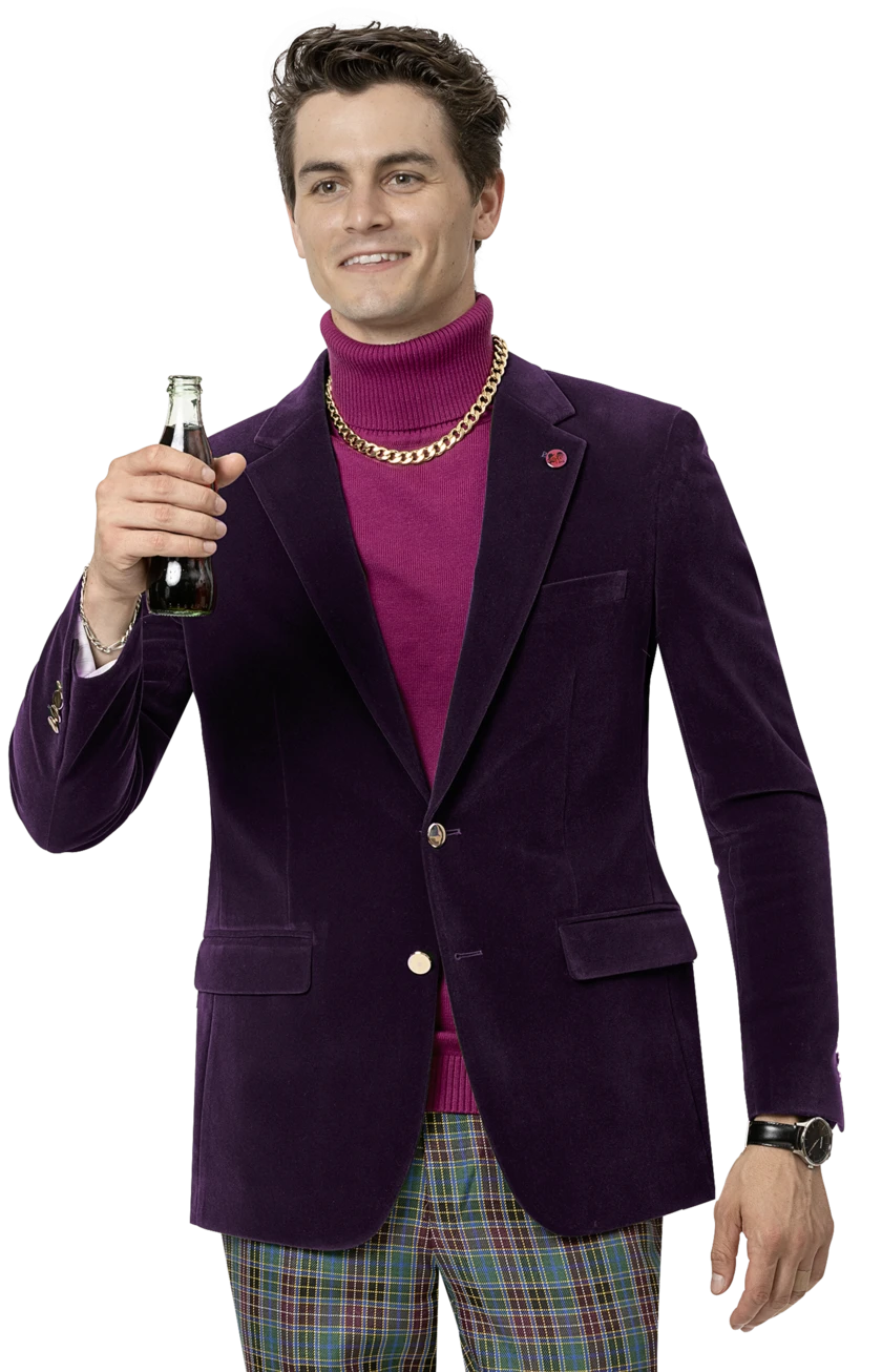 A person in an EJ Samuel Plum Velvet Blazer J134, featuring gold buttons, paired with a pink turtleneck, holds up a dark beverage bottle while wearing plaid pants and a gold chain necklace.