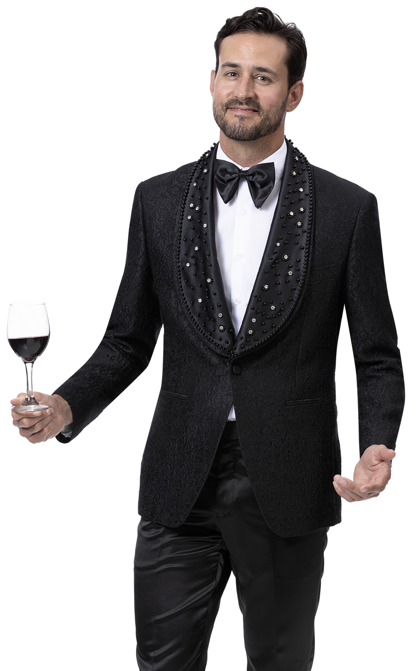 A man wearing the EJ Samuel Black Blazer J169 by EJ SAMUEL, featuring a detailed lapel, holds a wine glass while standing against a plain background, showcasing exquisite fashion.