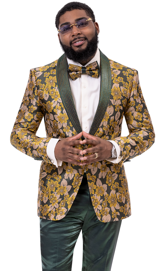 An individual confidently stands with hands clasped, wearing the striking EJ Samuel Green Suit JP105 from EJ SAMUEL, featuring green and gold floral designs, paired with a matching bowtie and glasses.