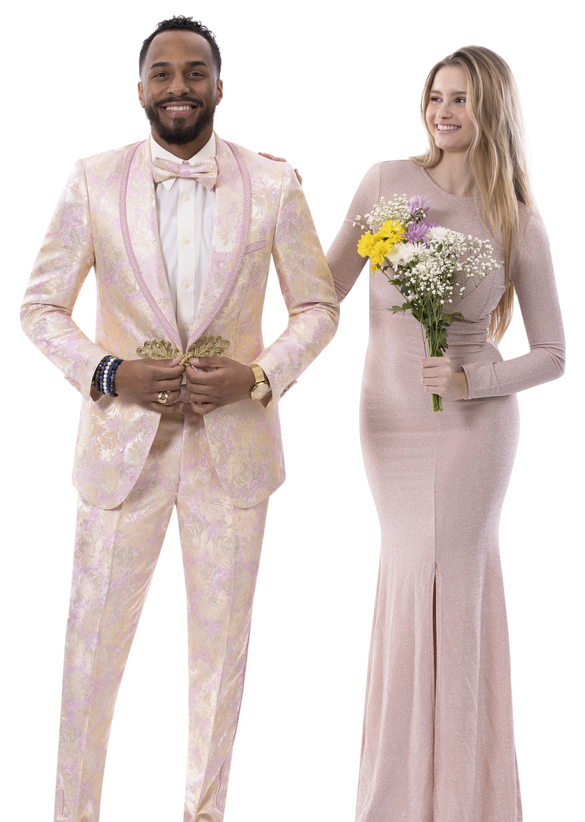 A man wearing the EJ Samuel Pink Suit JP111 by EJ SAMUEL, complete with a matching bowtie and boutonniere, stands beside a woman in a pink gown holding a bouquet and smiling.