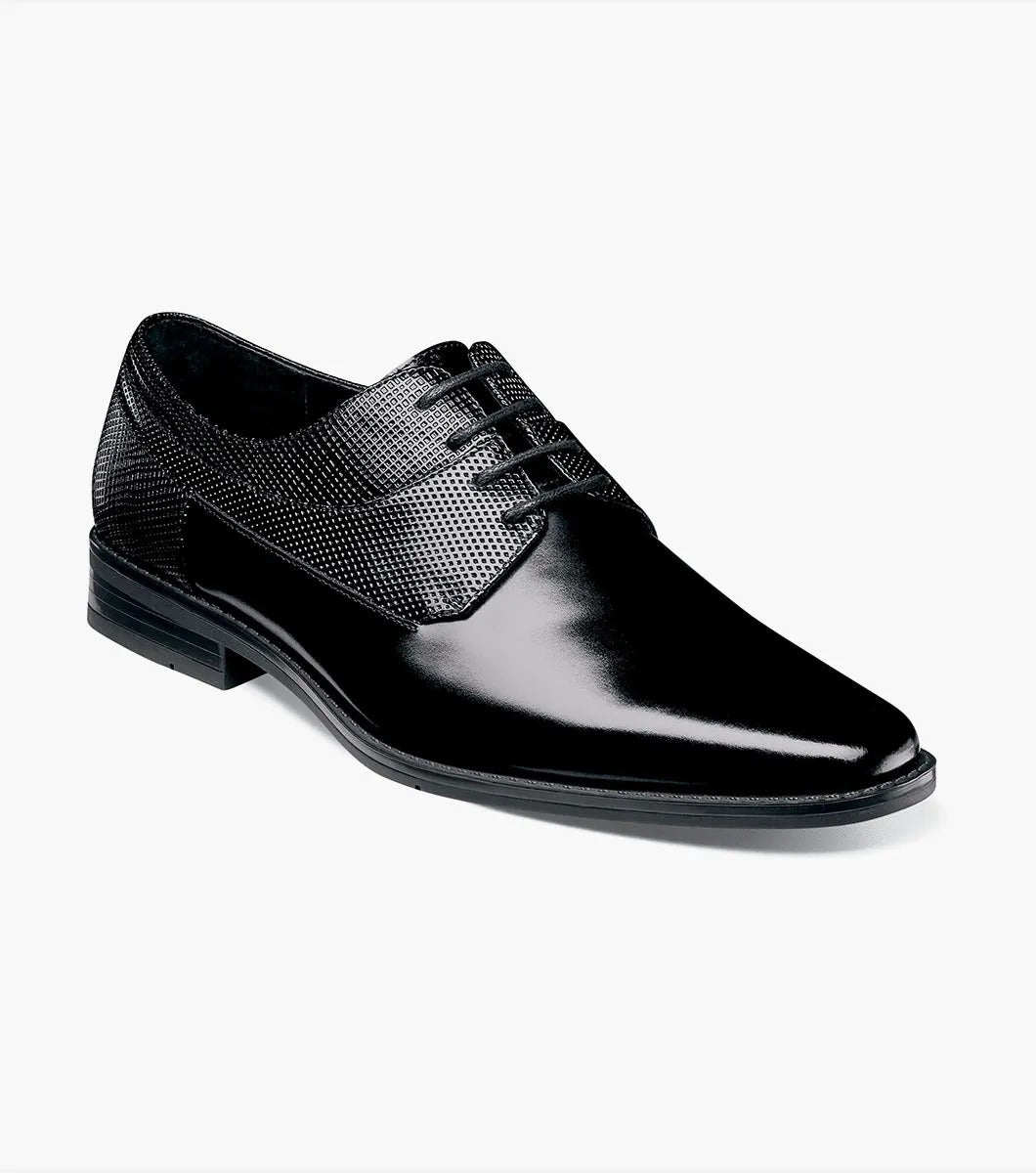 A single Stacy Adams Kirkley Plain Toe Oxford shoe in black, featuring a shiny finish and textured leather detailing on the sides.