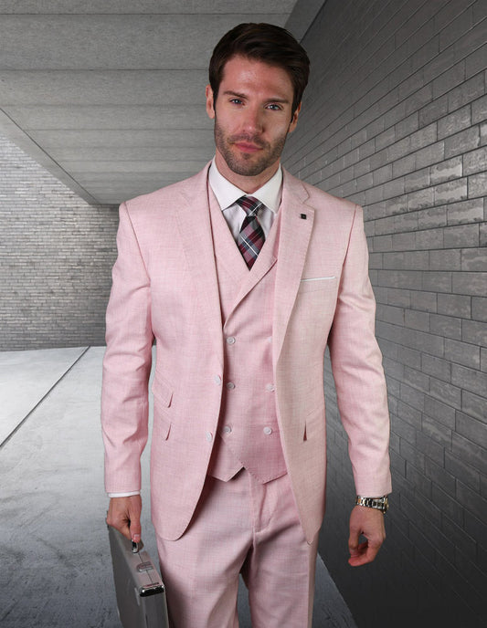 A man dressed in the Statement Clothing LANZO-PINK tailored-fit suit, complete with a tie and plaid vest, stands confidently in a gray corridor while holding a silver briefcase.