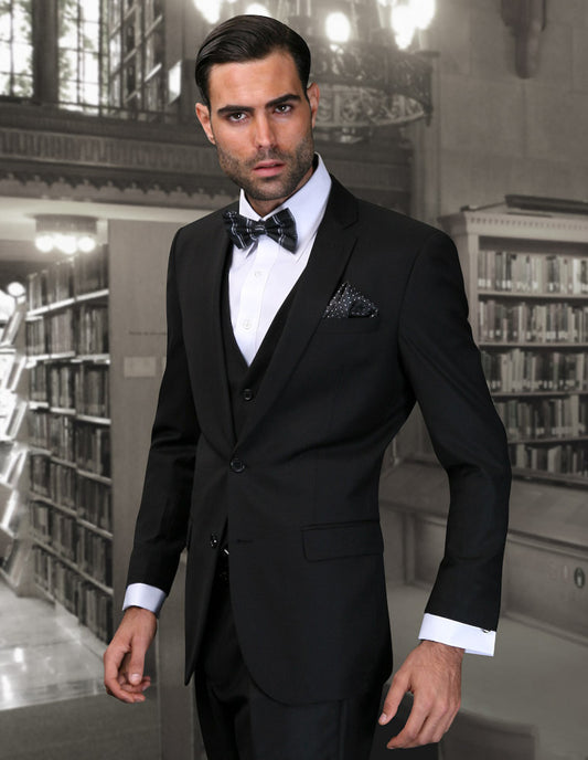 A man in a slim fit Lorenzo-Black tuxedo by Statement Clothing stands in a library, looking at the camera.