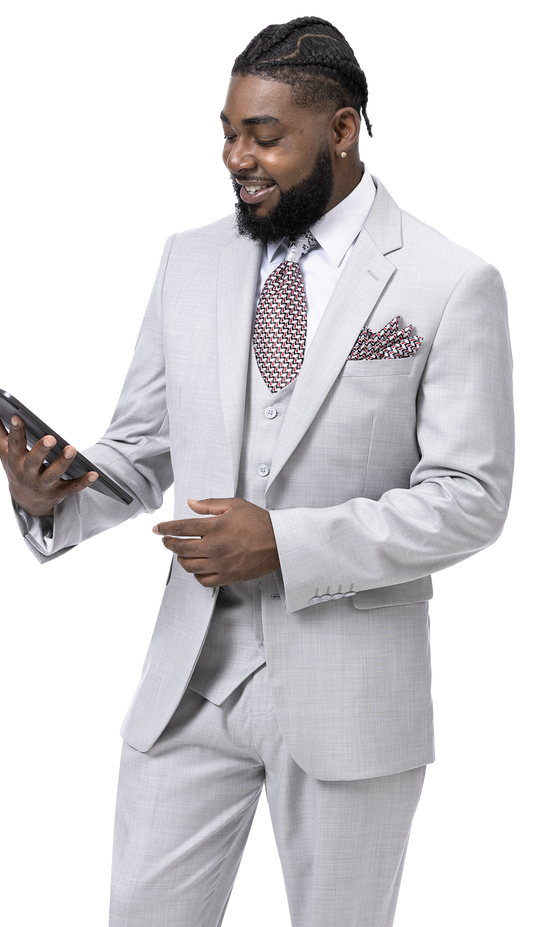 A man dressed in the EJ SAMUEL Gray Modern Fit Suit M18022, accessorized with a patterned tie and pocket square, is looking at a tablet.