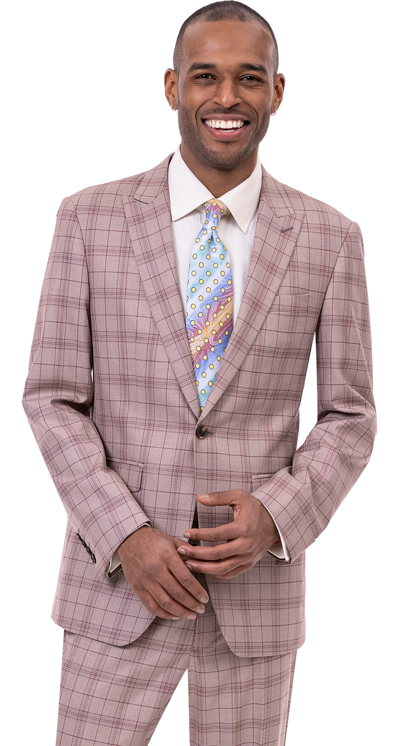 A person in the chic EJ Samuel Tan Suit M2768 and a patterned tie, smiling confidently against a plain background, embodying modern fashion.