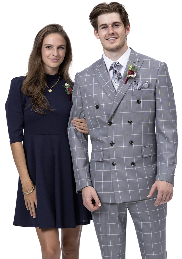 A woman in a navy dress stands next to a man wearing the EJ Samuel Gray Suit M2779, both exuding an aura of fashion and elegance as they smile warmly.