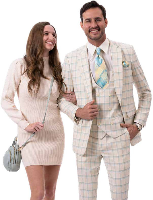 The woman in a beige dress and the man wearing an EJ Samuel teal suit, both smiling and linked arms, stand together.