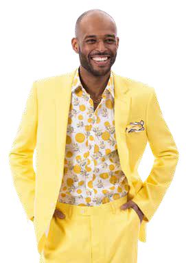 A person dressed in an EJ Samuel Yellow Suit M2792 with a floral-patterned shirt stands smiling with hands in pockets against a white backdrop.