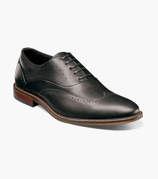 The Stacy Adams - MACARTHUR Wingtip Oxford in black (25489-001) by STACY ADAMS features brogue detailing, a burnished finish for a sophisticated look, and is crafted on a brown sole with arch support for all-day comfort.